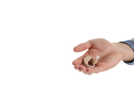 Hand holds hearing aid, isolated on white backgroundの写真素材