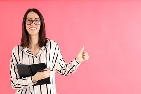 Young attractive woman in glasses on pink backgroundの写真素材