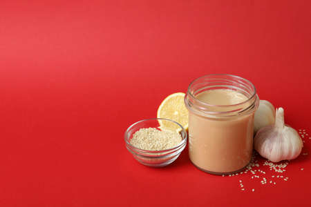 Concept of tasty food with tahini sauce on red backgroundの写真素材