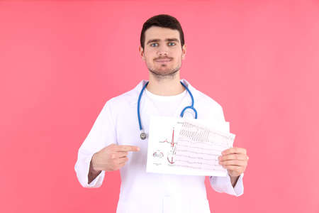 Doctor - intern with cardiogram on pink background
