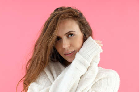 Attractive woman in sweater on pink backgroundの写真素材
