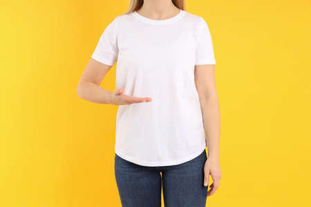 Woman in blank white t-shirt on yellow backgroundの写真素材