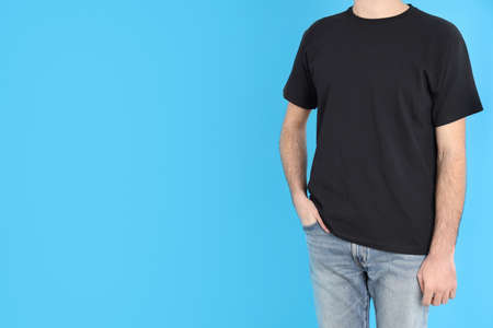 Man in blank black t-shirt on blue backgroundの写真素材