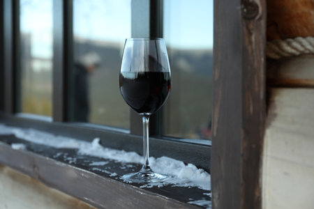 Glass of wine outdoor on windowsill in winter dayの写真素材