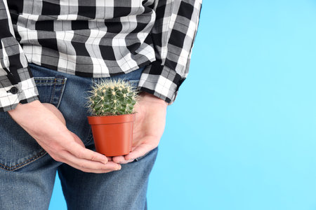 Man holds cactus near bottom. Hemorrhoids conceptの写真素材