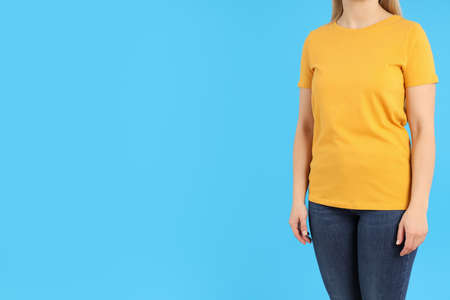 Woman in blank orange t-shirt on blue backgroundの写真素材