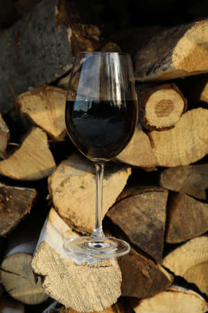 Glass of wine outdoor on folded firewood