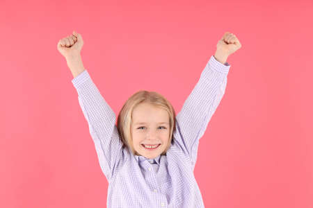 Happy little girl in shirt on pink backgroundの写真素材