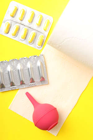 Concept of healthcare with hemorrhoids accessories on yellow background