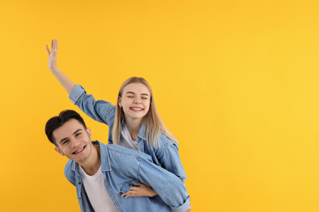 Cute and happy couple on yellow backgroundの写真素材