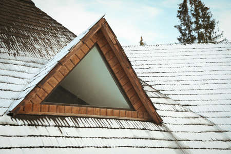 Roof of wooden house with snow in winter dayの写真素材