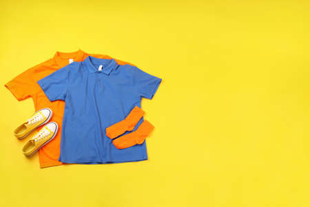 Blank t-shirts, sneakers and socks on yellow backgroundの写真素材
