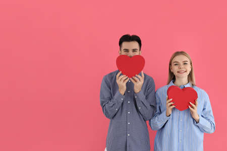 Cute couple with hearts on pink backgroundの写真素材