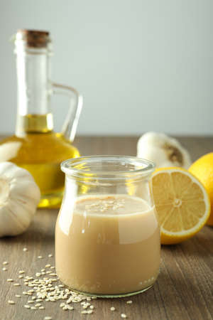 Concept of tasty food with tahini sauce on wooden table