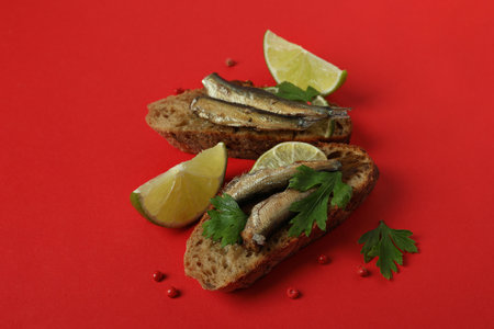 Tasty sandwiches with sprats on red backgroundの写真素材