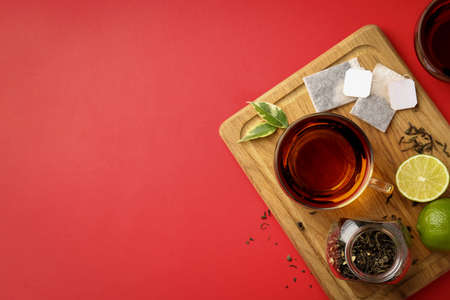 Concept of hot drink with tea on red backgroundの写真素材