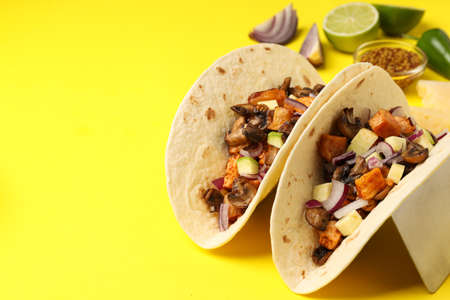 Concept of tasty food with taco on yellow backgroundの写真素材