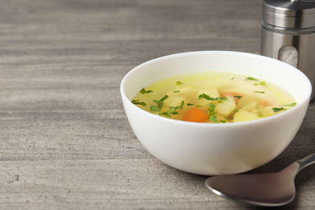 Chicken soup on gray textured background, top viewの写真素材