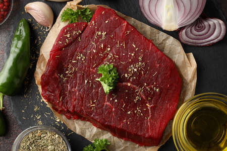 Concept of cooking with raw steak, close up