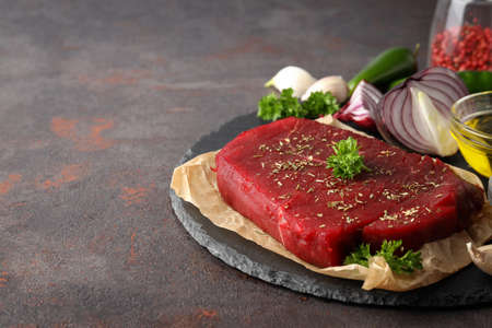 Concept of cooking with raw steak on textured background