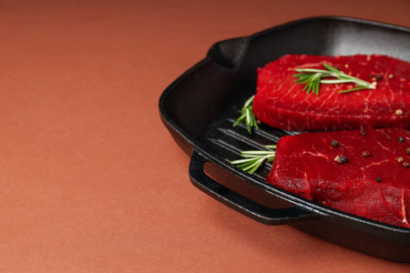 Concept of cooking with raw steak on brown backgroundの写真素材