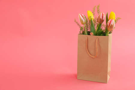 Paper bag with flowers on pink backgroundの写真素材