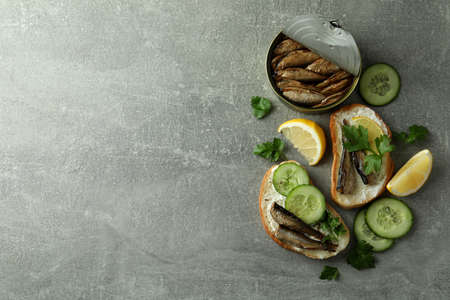 Concept of tasty snack with sandwiches with sprats on gray textured backgroundの写真素材
