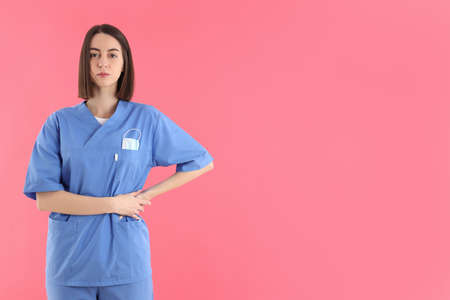 Young female trainee nurse on pink backgroundの写真素材