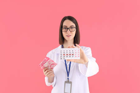 Female doctor with thermometer gun on yellow background
