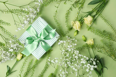 Gift box with flowers on green backgroundの写真素材