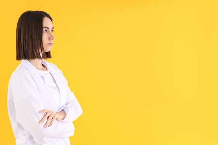 Female doctor on yellow background, space for text