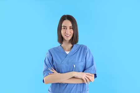 Young female trainee nurse on blue backgroundの写真素材