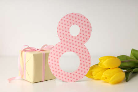 Tulips, gift box and 8 on white table