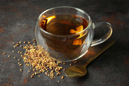 Concept of hot drink with buckwheat tea on dark textured background