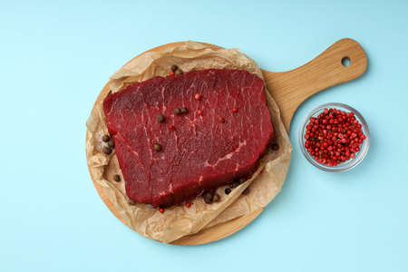 Concept of cooking with raw beef steak on blue backgroundの写真素材