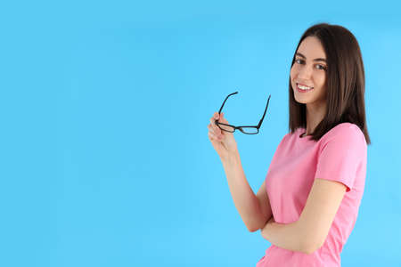 Young attractive woman in t-shirt on blue backgroundの写真素材