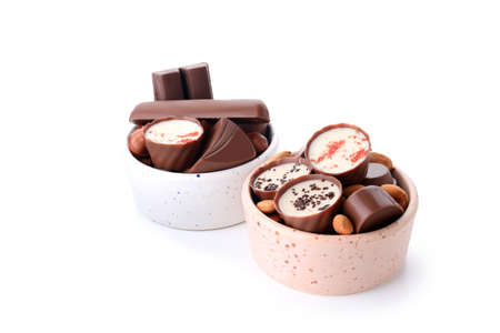 Chocolate candy in bowls isolated on white backgroundの写真素材
