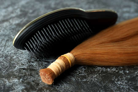 A lock of female hair and hairbrush, close upの写真素材