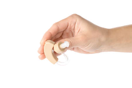 Hand holds hearing aid, isolated on white background