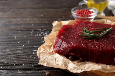 Concept of tasty food with raw beef steak on wooden backgroundの写真素材