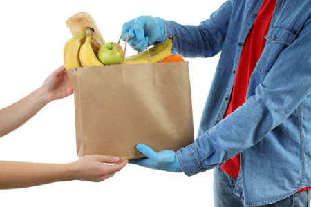 Delivery man give bag with food, isolated on white background