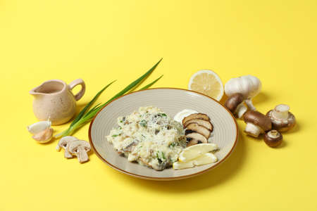 Concept of tasty food with risotto with mushrooms on yellow backgroundの写真素材
