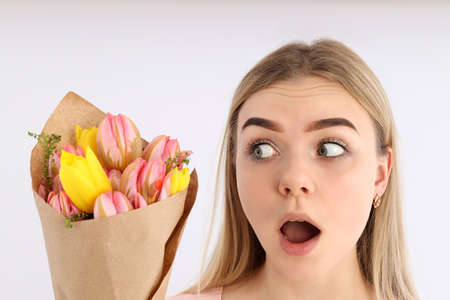 Excited girl with bouquet of flowers on white backgroundの写真素材