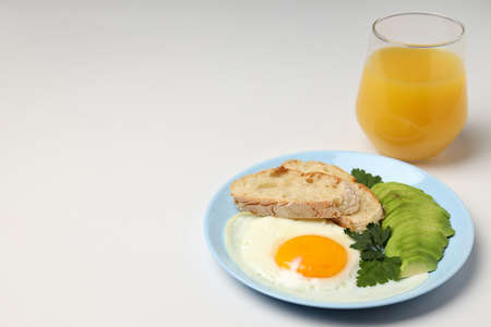 Plate of breakfast and glass of juice on white backgroundの写真素材