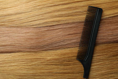 Female hair with hairbrush on whole backgroundの写真素材