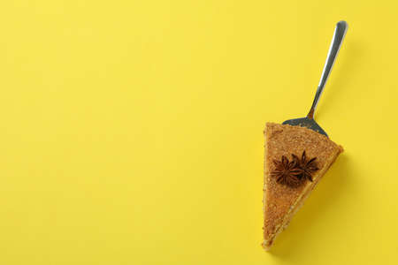 Cake spatula with honey cake on yellow backgroundの写真素材