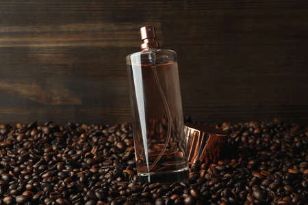 Bottle of perfume on coffee seeds against wooden backgroundの写真素材