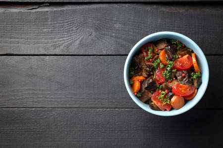 Plate with beef and vegetables on wooden backgroundの写真素材