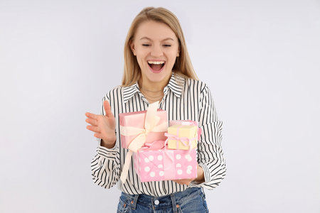 Young woman with gift boxes on white background