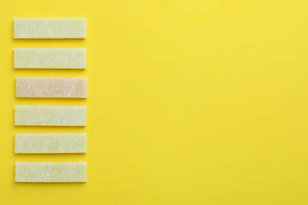 Chewing or bubble gum on yellow background, space for text